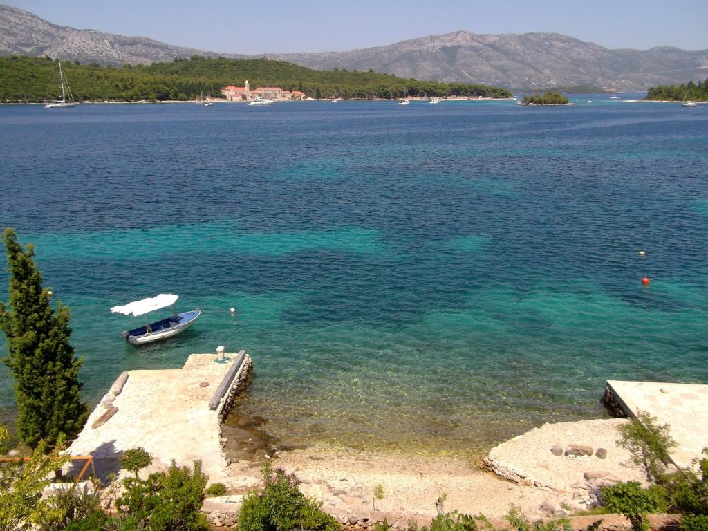 widok na jezioro z łodzią w wodzie w obiekcie Soline accommodation w Korčuli