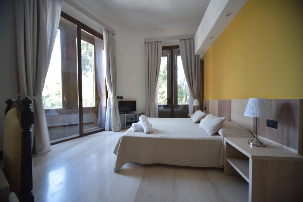 a bedroom with a bed and a couch and windows at B&B Del Duomo in Messina