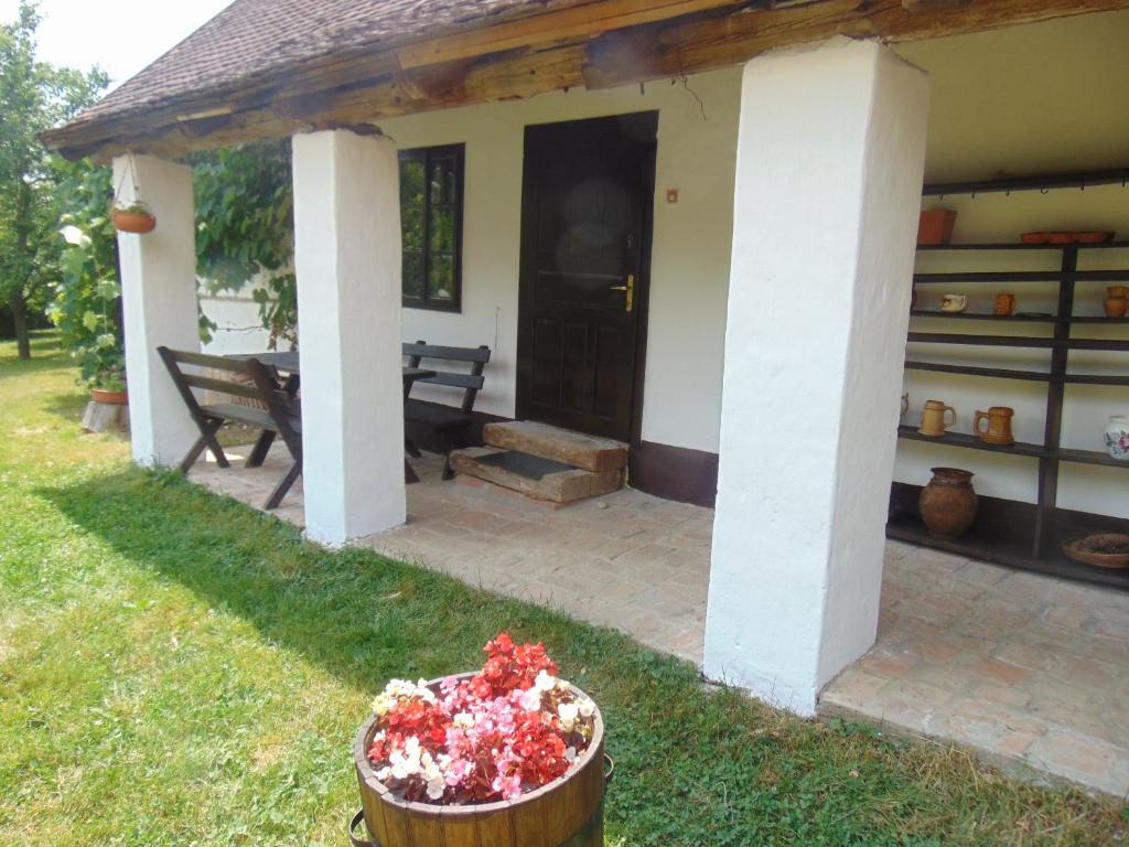 une terrasse couverte d'une maison avec un banc et une table dans l'établissement Rigó Vendégház, à Őriszentpéter