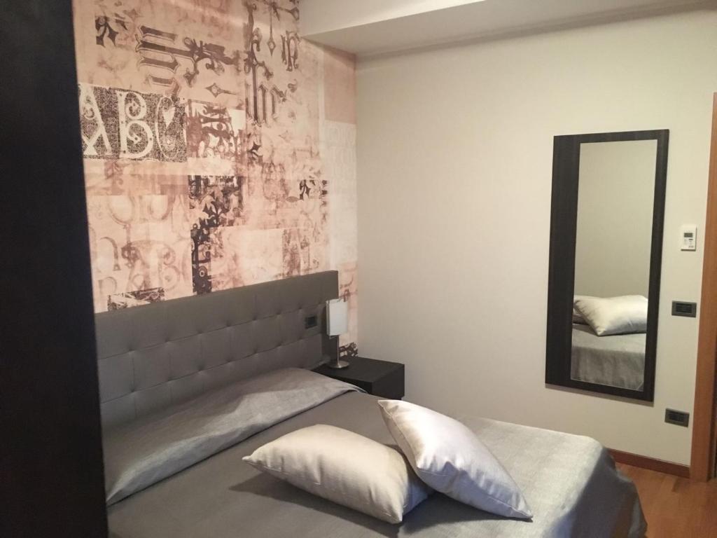 DubinoにあるHotel Maloiaのベッドルーム(大きな鏡付きのベッド付)