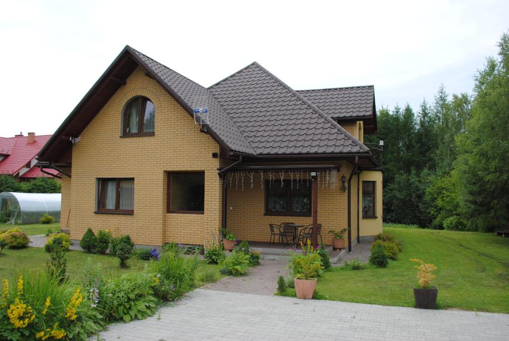 a yellow house with a black roof at Dom Gościnny in Polańczyk