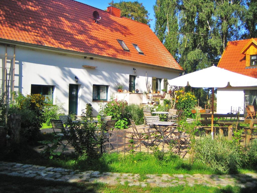 因塞爾波埃爾的住宿－Haus Sturmfried，白色的房子,有橙色的屋顶和庭院