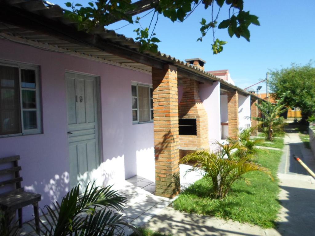 een roze huis met een deur en een tuin bij Pousada do Mar in Rio Grande