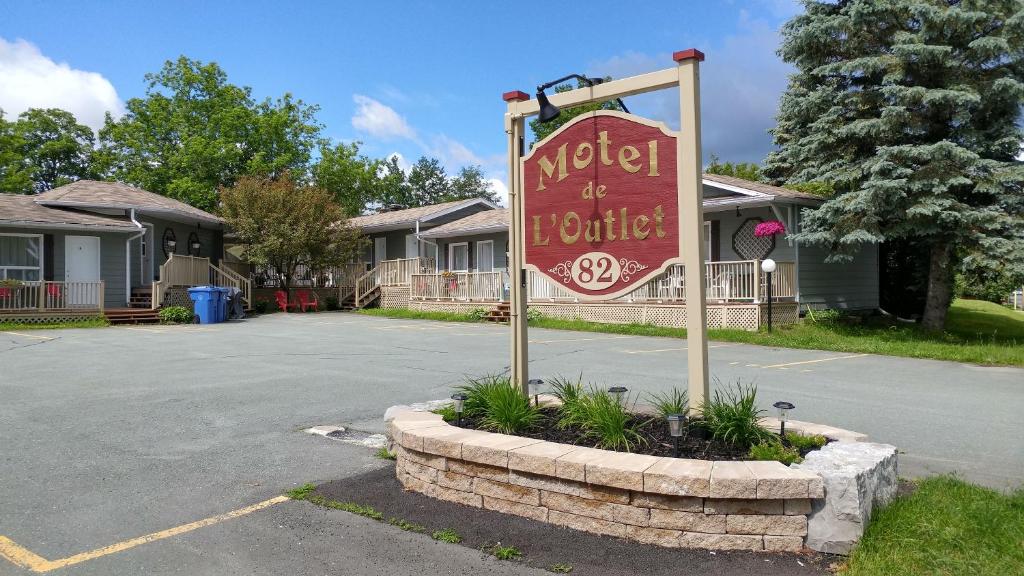 una señal de motel frente a un estacionamiento en Motel de l'Outlet, en Magog-Orford
