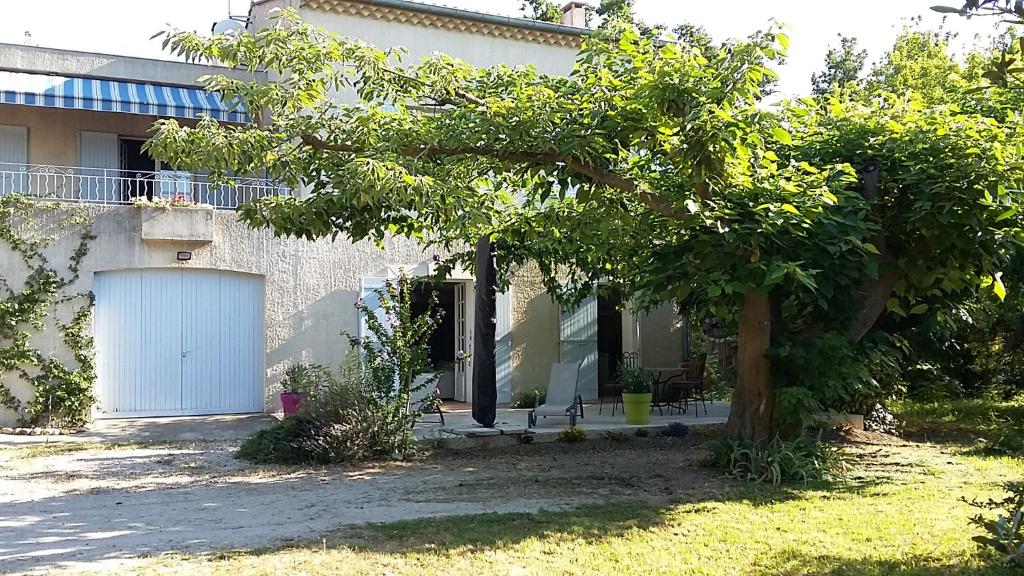 una casa con un albero di fronte di Au charme et à la campagne ad Avignone