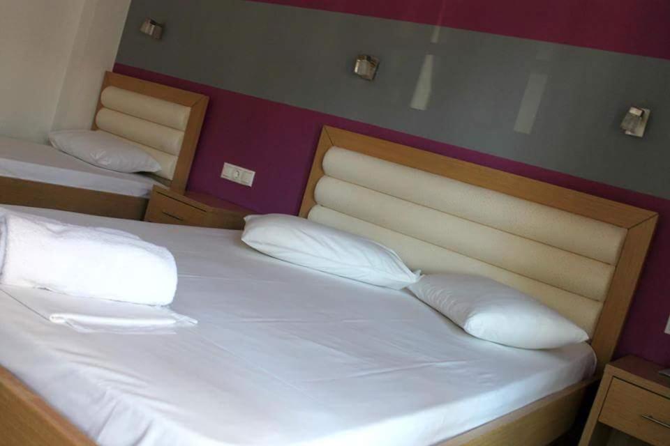 レプトカリヤにあるGia Banakiの白い枕が備わる客室内のベッド2台