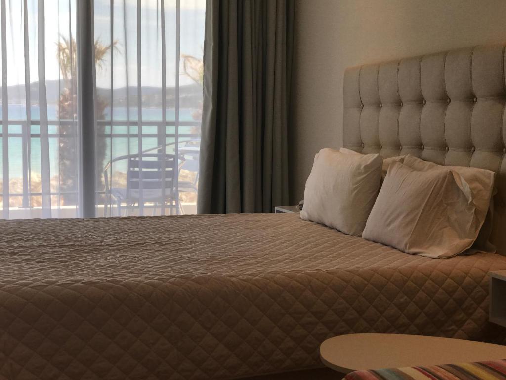 A bed or beds in a room at Porto Palio Beach Hotel