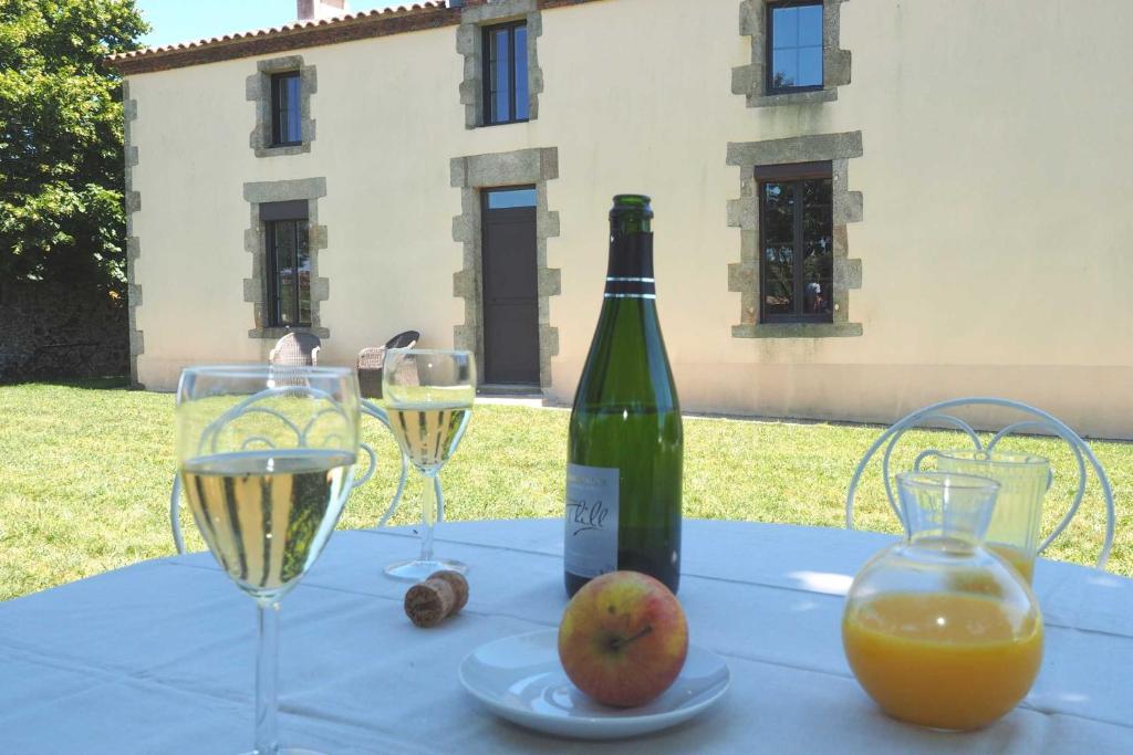 una mesa con una botella de vino y dos copas en Hameau de La Landrière à 3 min du Puy du Fou en Saint-Malo-du-Bois