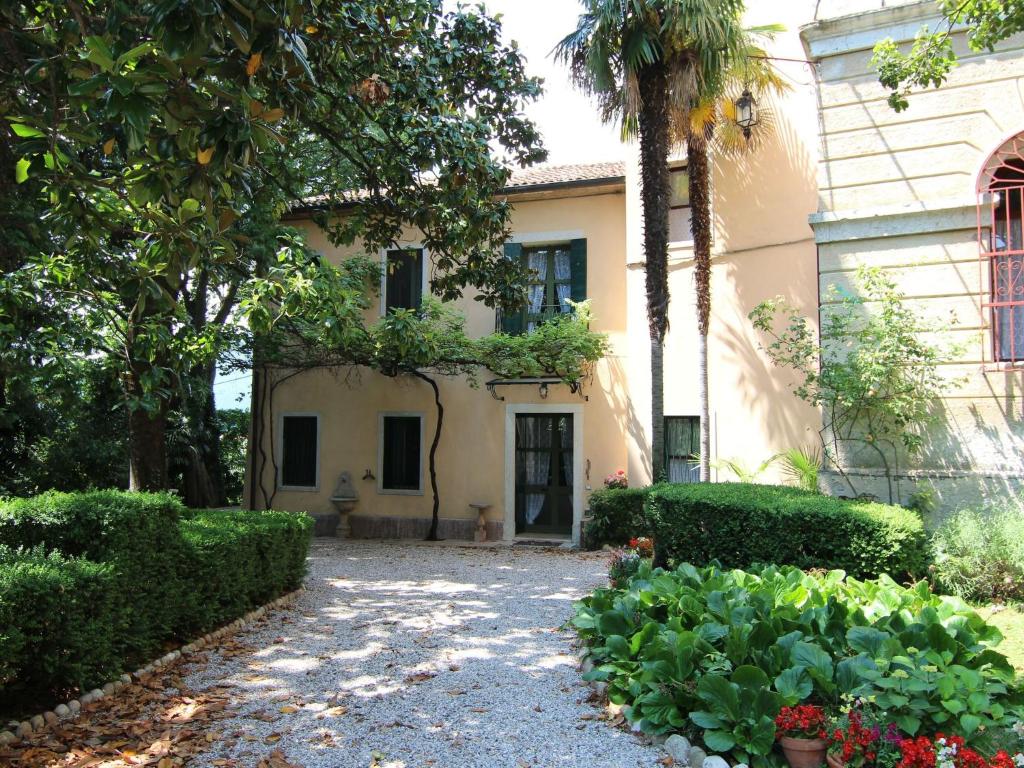 a house with a palm tree and a driveway at Belvilla by OYO Villa Fiorita Uno in Romano D'Ezzelino