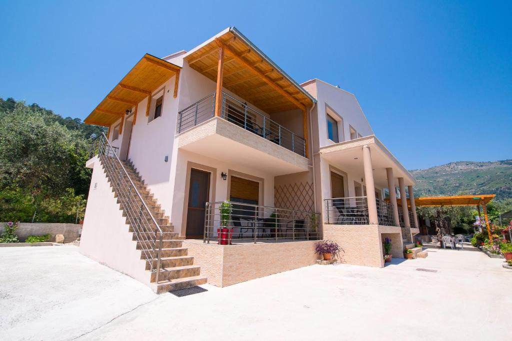 a house with a staircase in front of it at Kapsogeorgis Rooms in Koinyra