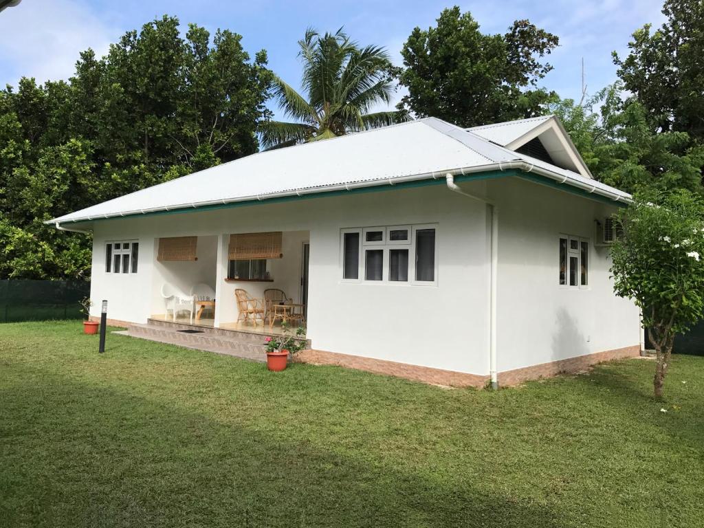 a white house with a grass yard at Fadine Self Catering in La Digue