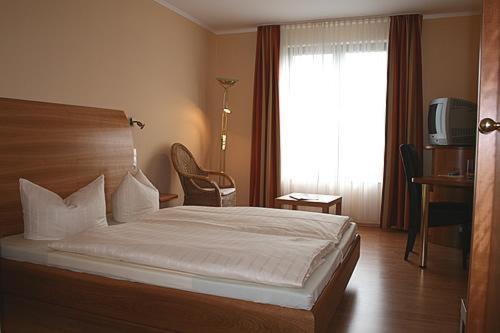 ein Schlafzimmer mit einem großen Bett und einem Fenster in der Unterkunft Hotel Wadegotia in Wadgassen