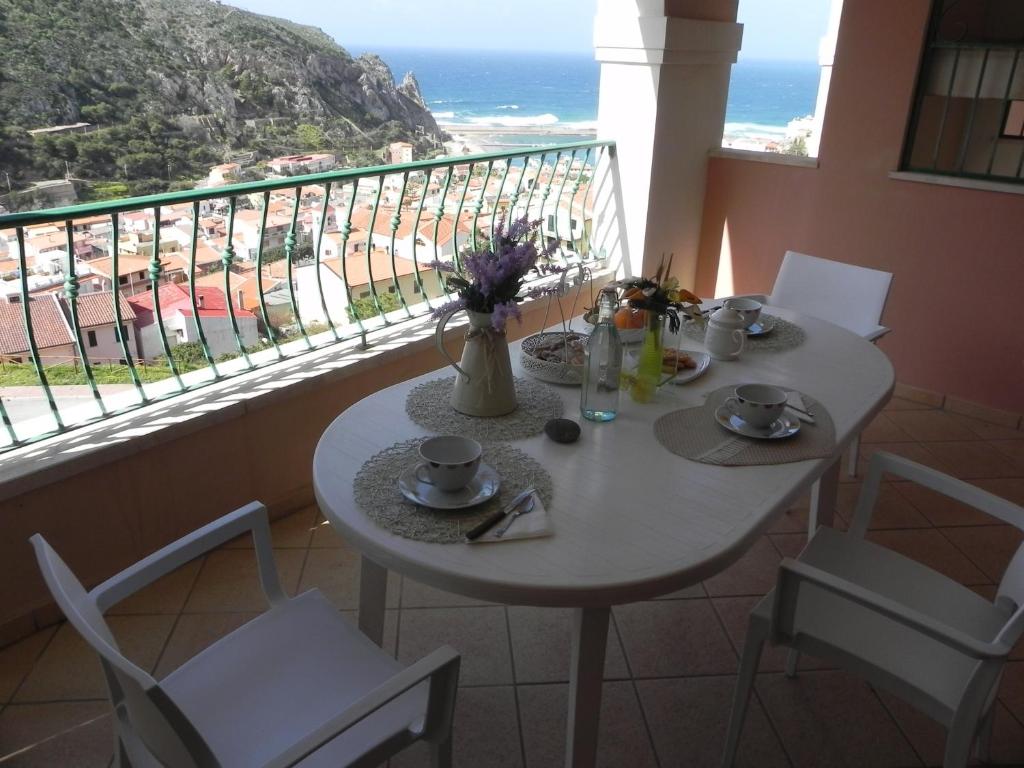 a table and chairs with a view of the ocean at Buggerru a Mare Residence in Buggerru