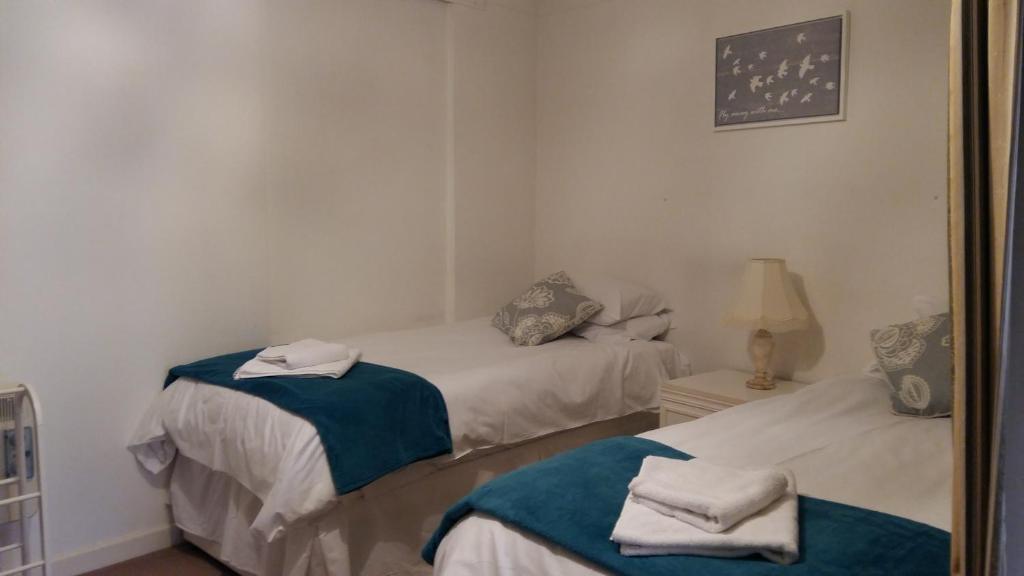 two beds in a room with a mirror at Clarence Road Apartment in Gosport