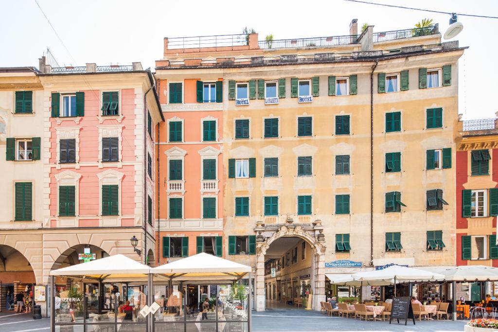 um edifício com mesas e guarda-chuvas à sua frente em Albergo La Piazzetta em Rapallo