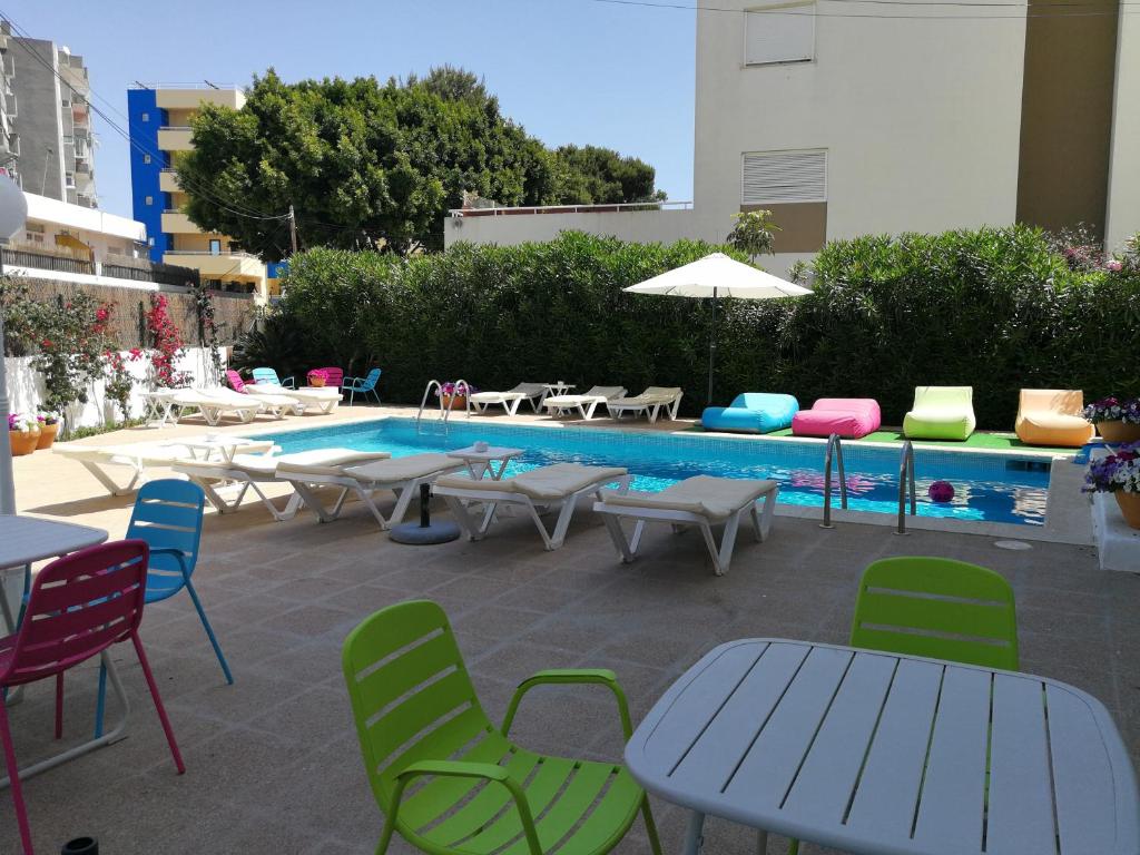 a patio with tables and chairs next to a pool at Apartamentos Es Cantó in Playa d'en Bossa