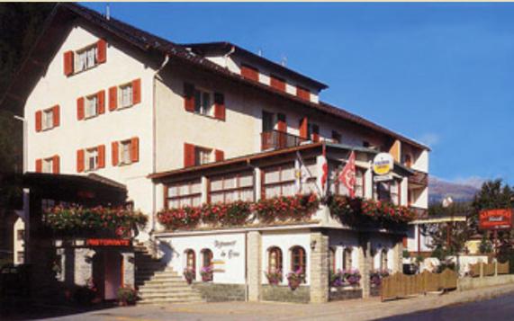 ein großes weißes Gebäude mit Blumen davor in der Unterkunft Albergo Lardi in Le Prese, Poschiavo