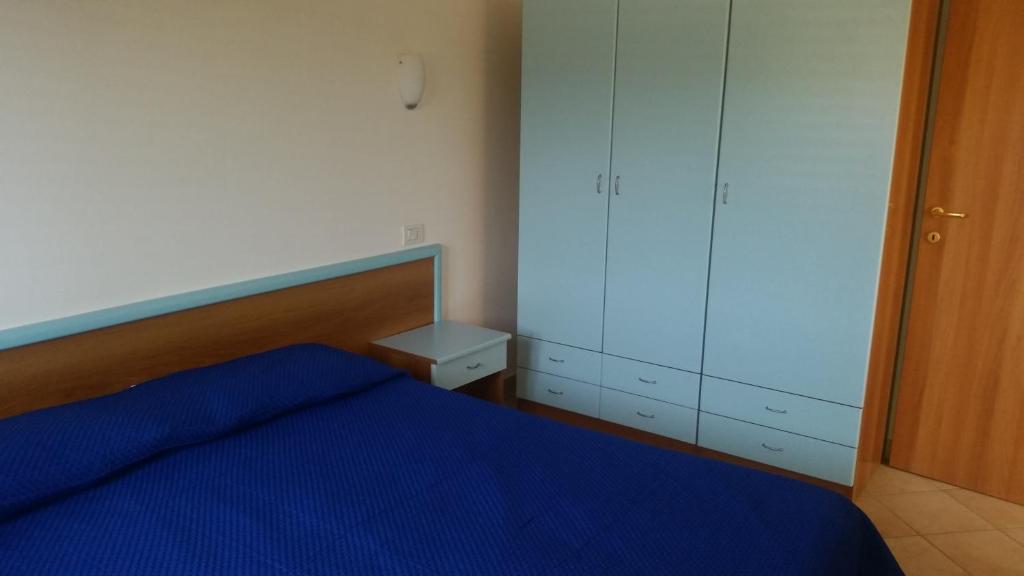 1 dormitorio con cama azul y armario en Bianchito Sea, en Peschici