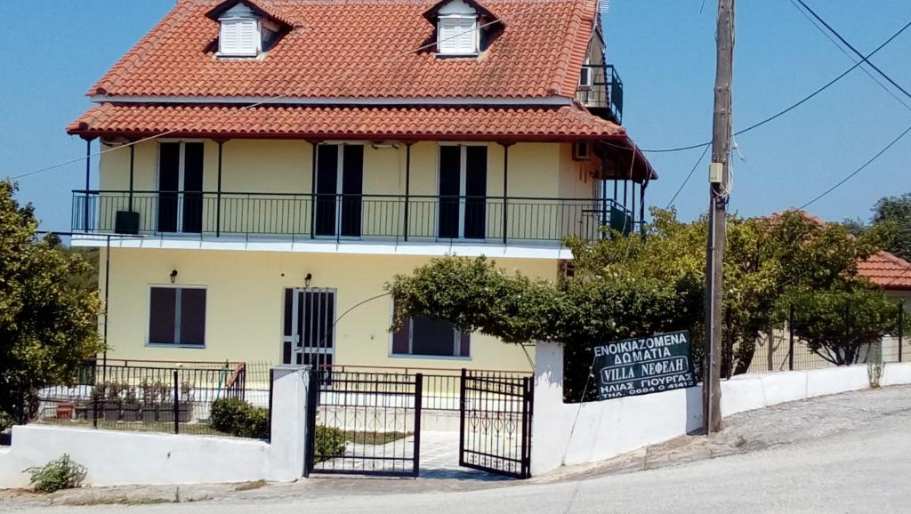a yellow house with a red roof at Villa Nefeli in Loutsa
