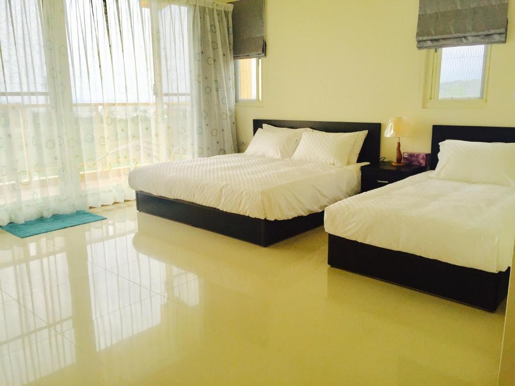 a bedroom with two beds and a window at Tamowan in Donghe