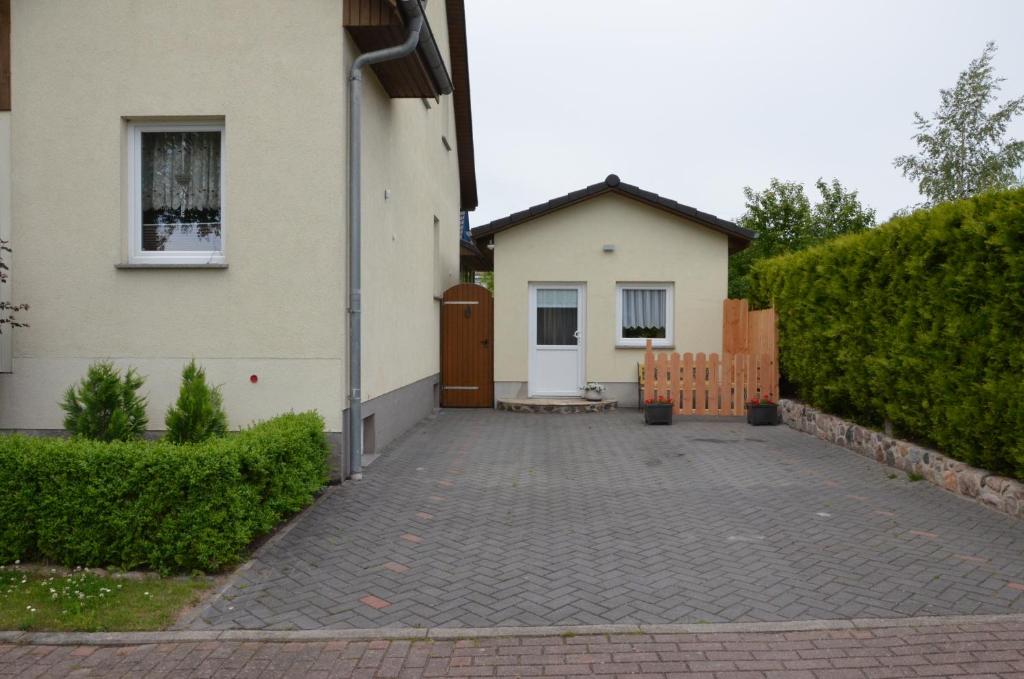 a house with a brick driveway next to a building at Ferienzimmer *Auszeit* in Sassnitz