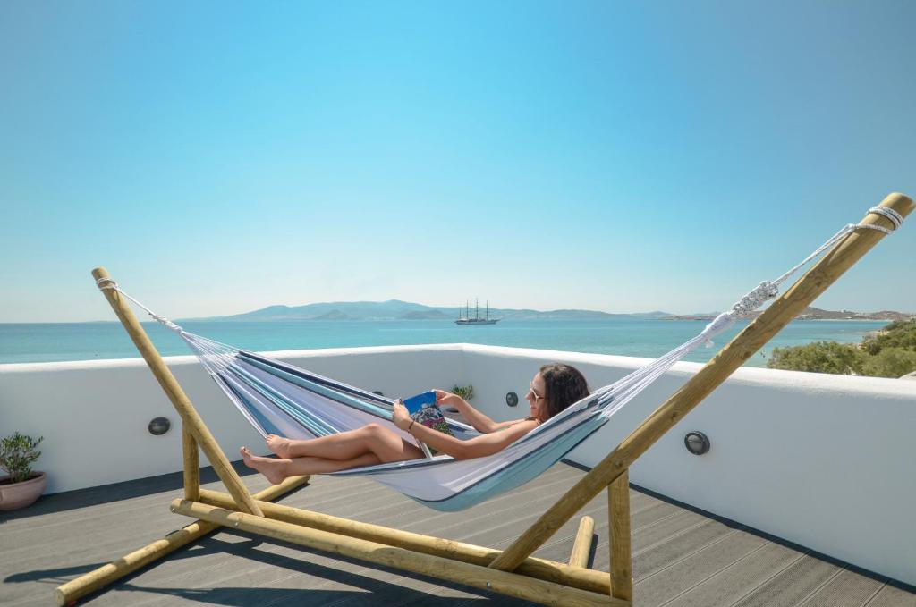 dos mujeres tumbadas en una hamaca en una terraza en Naxian Althea, en Agia Anna de Naxos