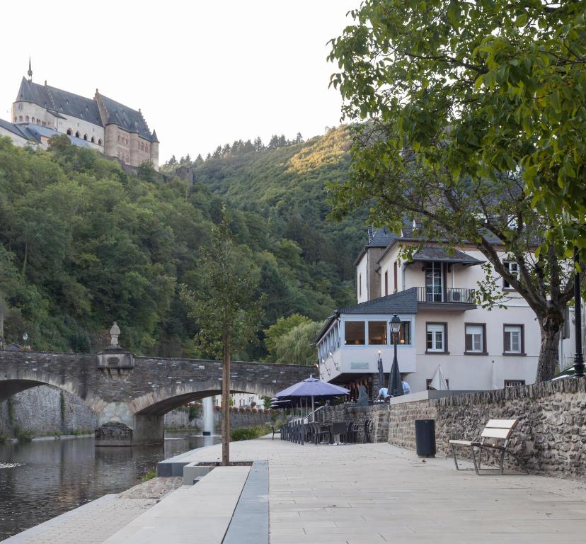 uma ponte sobre um rio ao lado de um edifício em Auberge de Vianden em Vianden