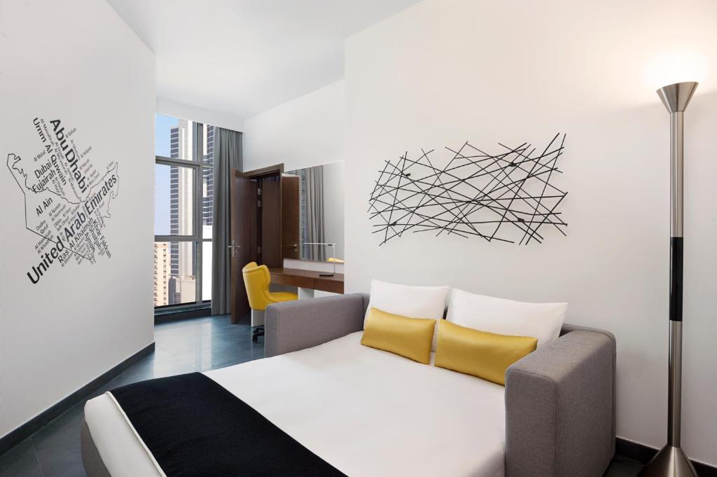 a bedroom with a bed with yellow pillows at TRYP by Wyndham Dubai in Dubai