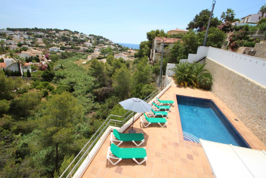 ベニッサにあるElena Baladrar - sea view villa with private pool in Benissaのラウンジチェアとパラソル付きのスイミングプールを併設しています。