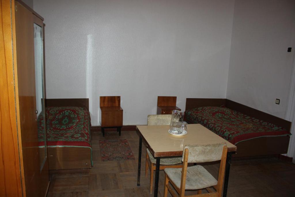 una stanza con un letto, un tavolo e delle sedie di Firuza Hostel a Borjomi