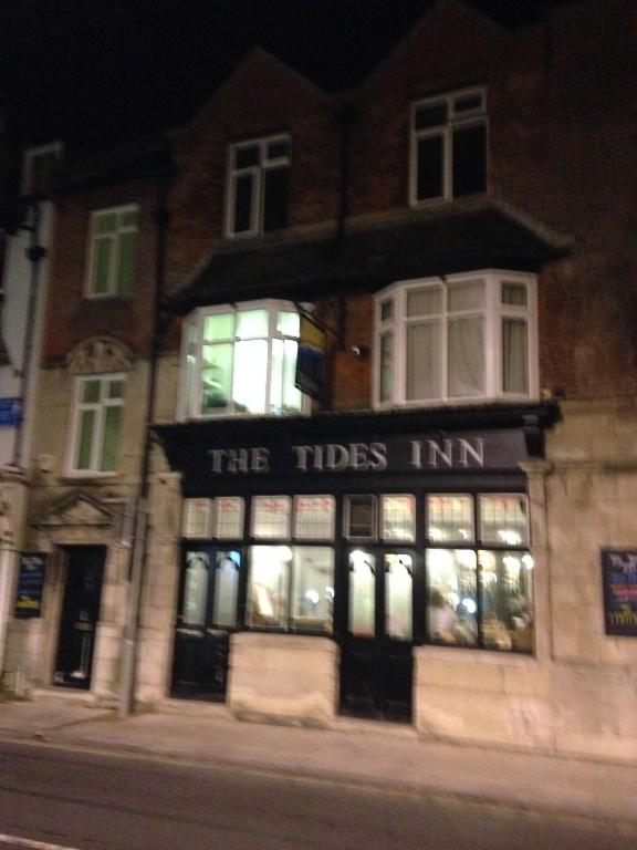 a building with the tides inn at night at The Tides Inn in Weymouth