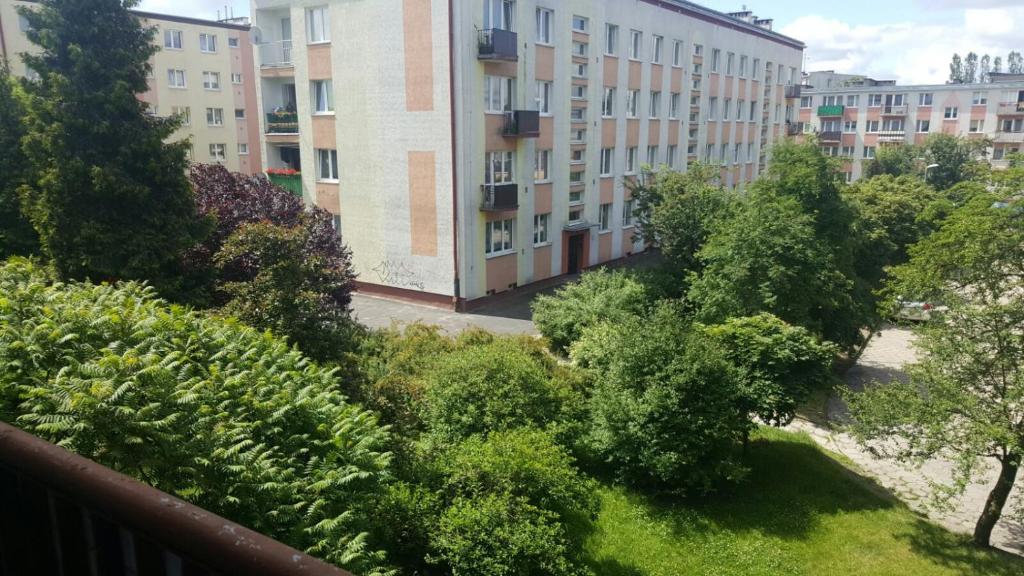 - un balcon avec des buissons, des arbres et des bâtiments dans l'établissement Apartamenty Iława, à Iława