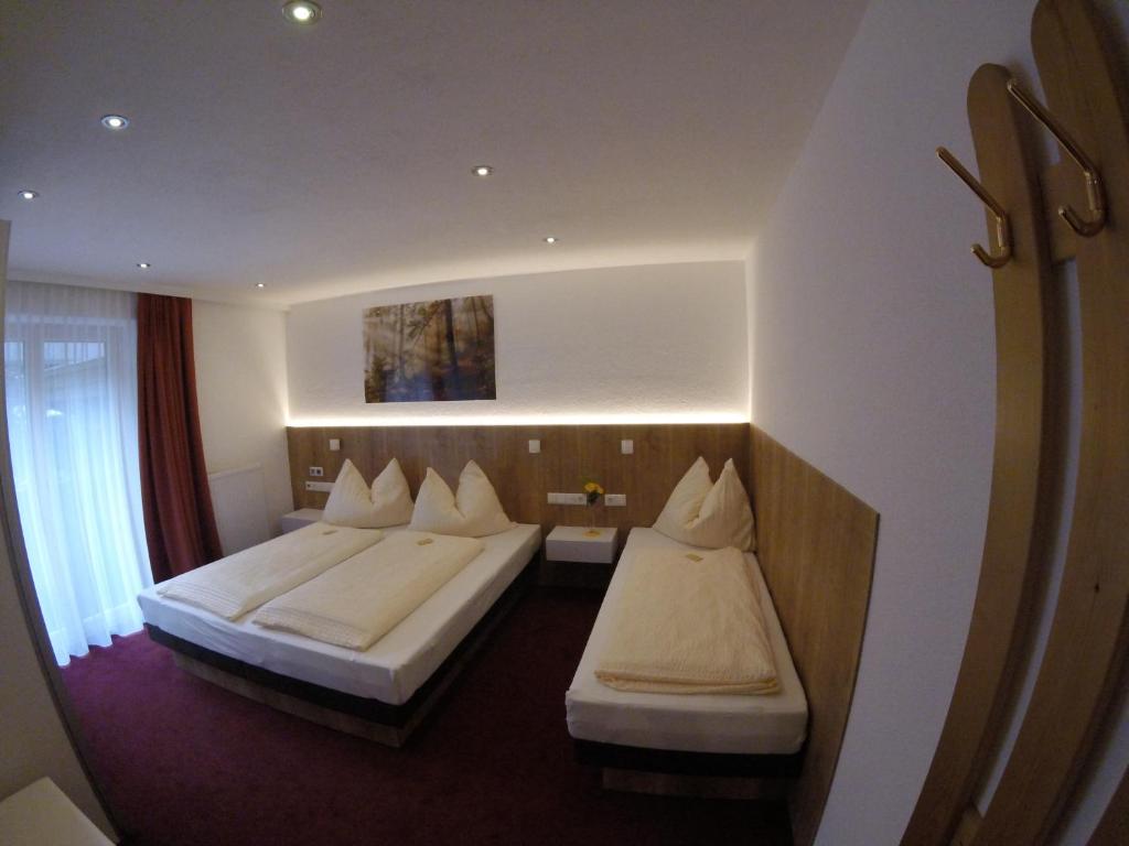 a hotel room with two beds and a window at Komfort Appartements Talbach in Hippach
