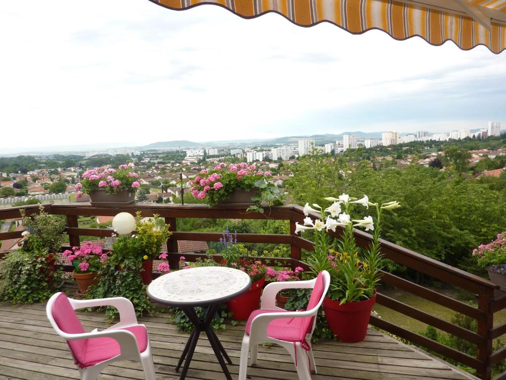 une table et des chaises sur une terrasse fleurie dans l'établissement Les Terrasses de Bellemoure Cébazat, à Cébazat