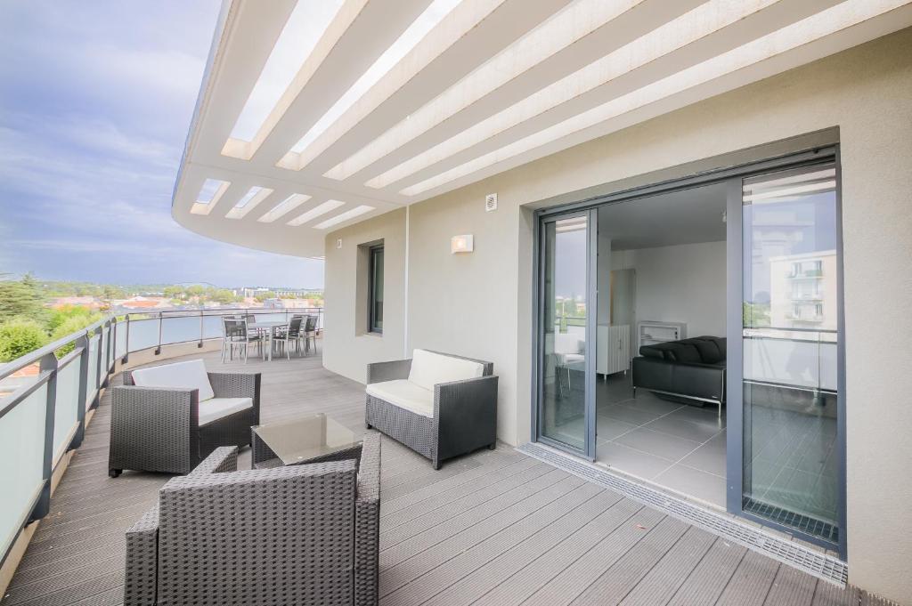 - un balcon avec des canapés et des chaises dans un bâtiment dans l'établissement Le 180°, à Montpellier