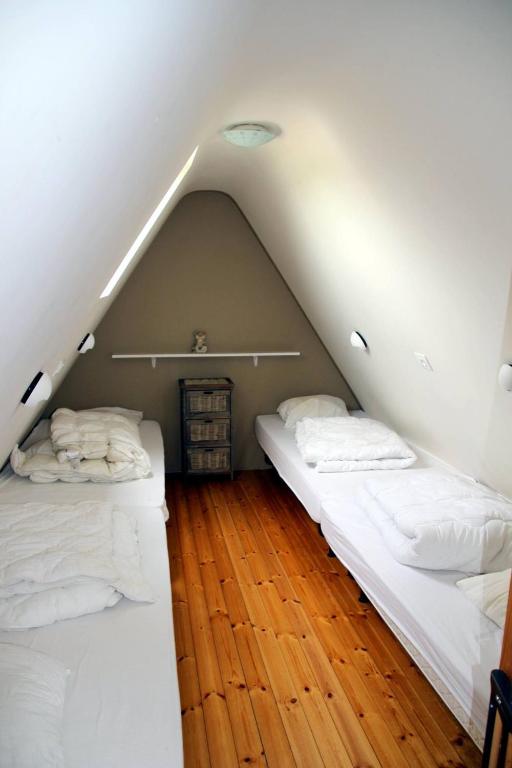 two beds in a room with a attic at Holiday home Het Zeugekot in Beveren