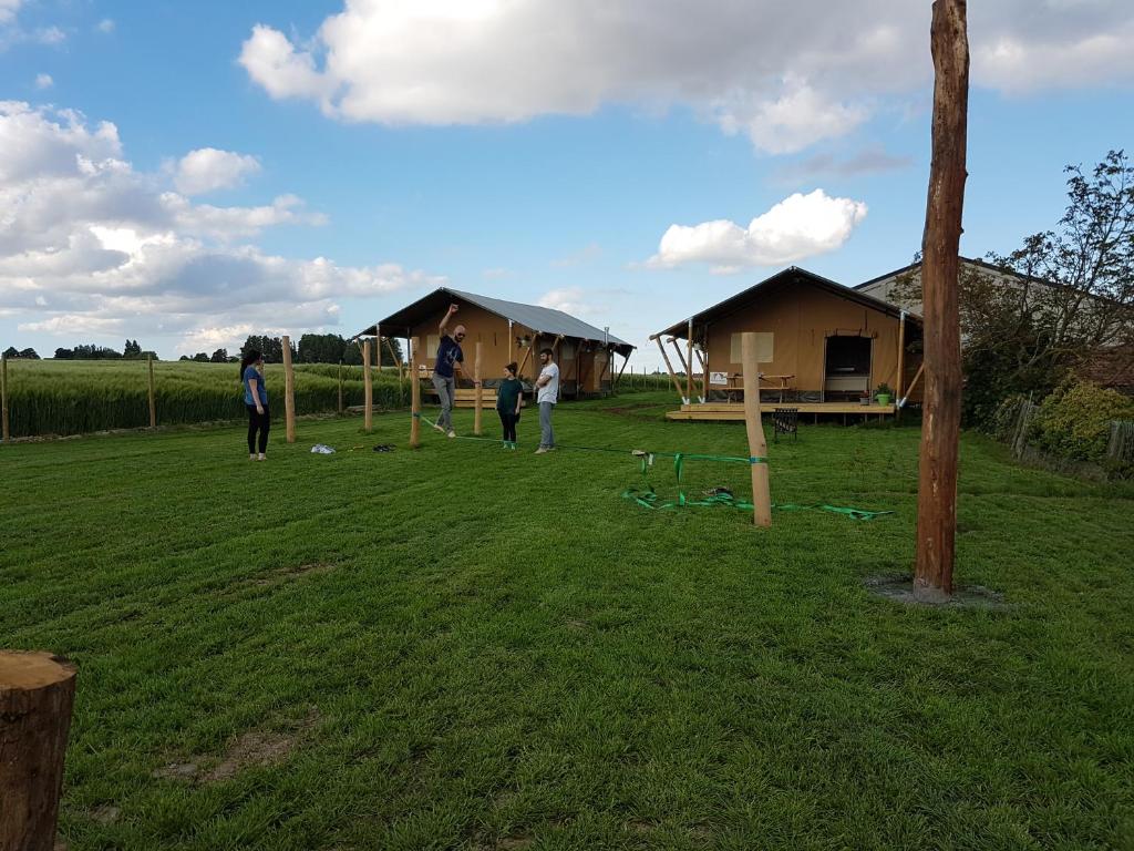 een groep mensen in een veld met hutten bij Glamping op het Zeugekot in Beveren