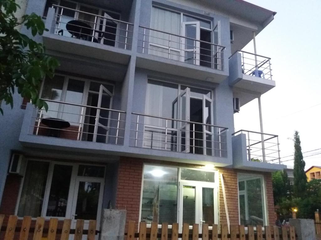 a house with balconies and a fence in front of it at Hotel Aurora in Ureki