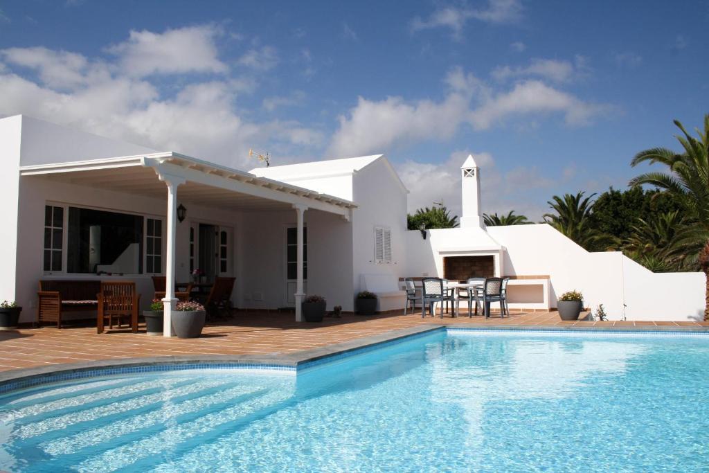 Villa con piscina frente a una casa en VILLA MANUELA by Buenavilla, en Puerto Calero