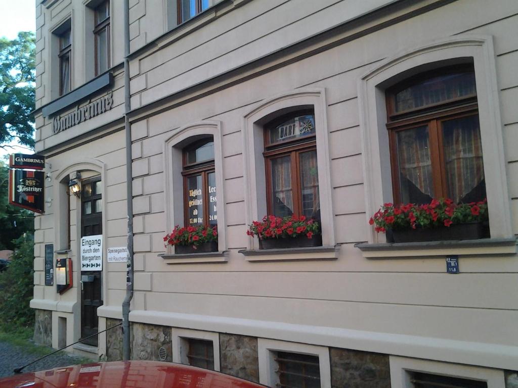 budynek z trzema oknami z kwiatami w obiekcie Gästezimmer in Lindenau w Lipsku