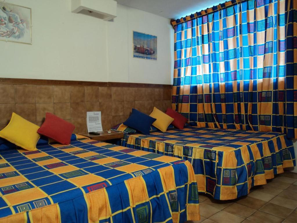 2 camas con almohadas coloridas en una habitación en Canadian Resort Veracruz, en Costa Esmeralda