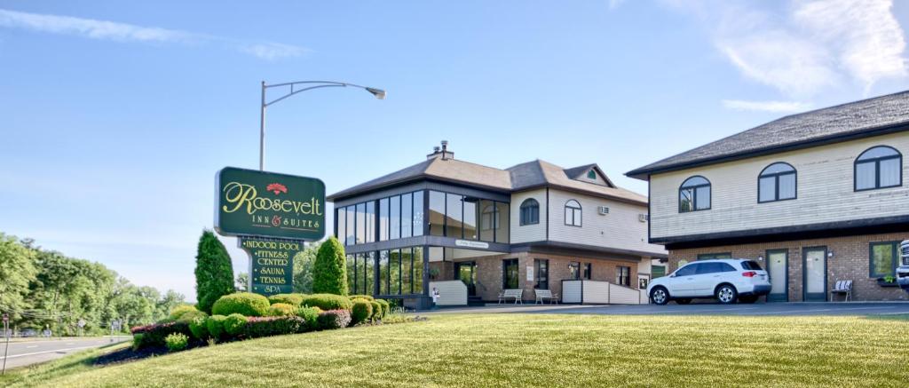 un edificio con un coche aparcado delante de él en Roosevelt Inn & Suites Saratoga Springs, en Saratoga Springs