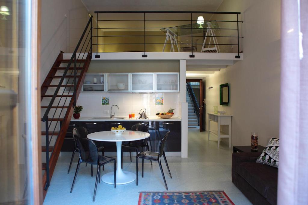 a kitchen and a living room with a table and a loft at Palazzo Ossuna in Trapani