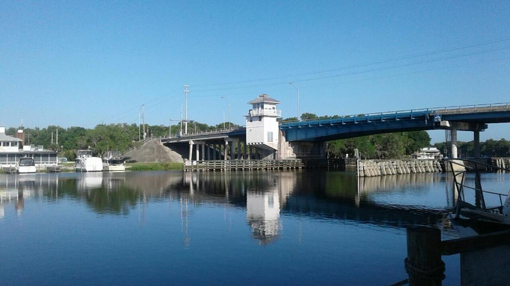 a bridge over a river with a lighthouse and a bridge at Big River Marina & Lodge in Astor