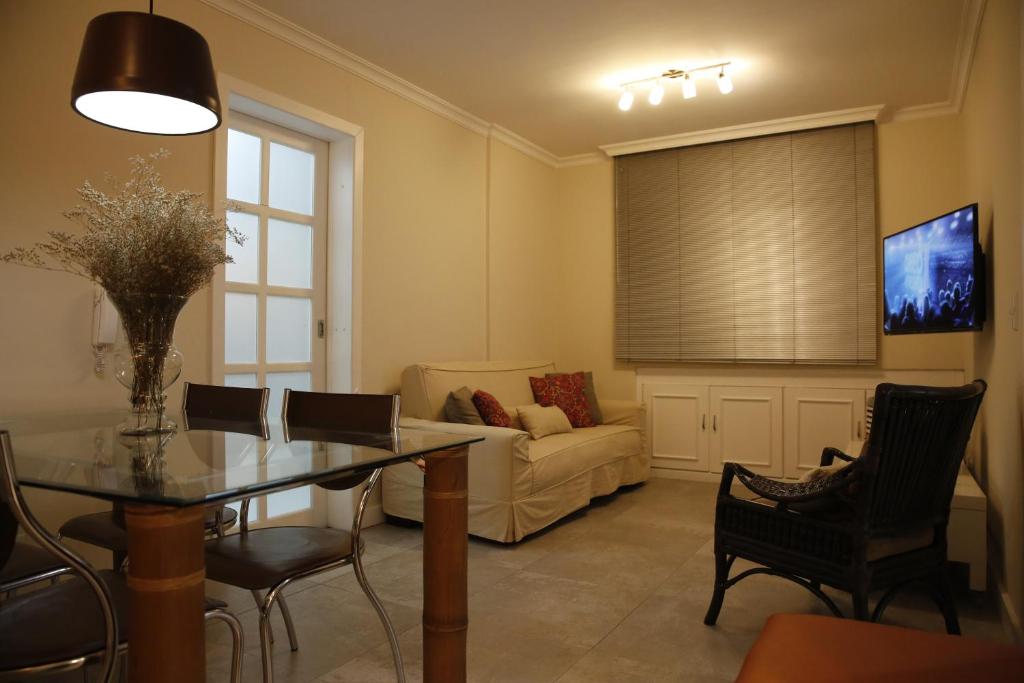 a living room with a table and a couch at Apartamento central, novo e com garagem em Curitiba in Curitiba