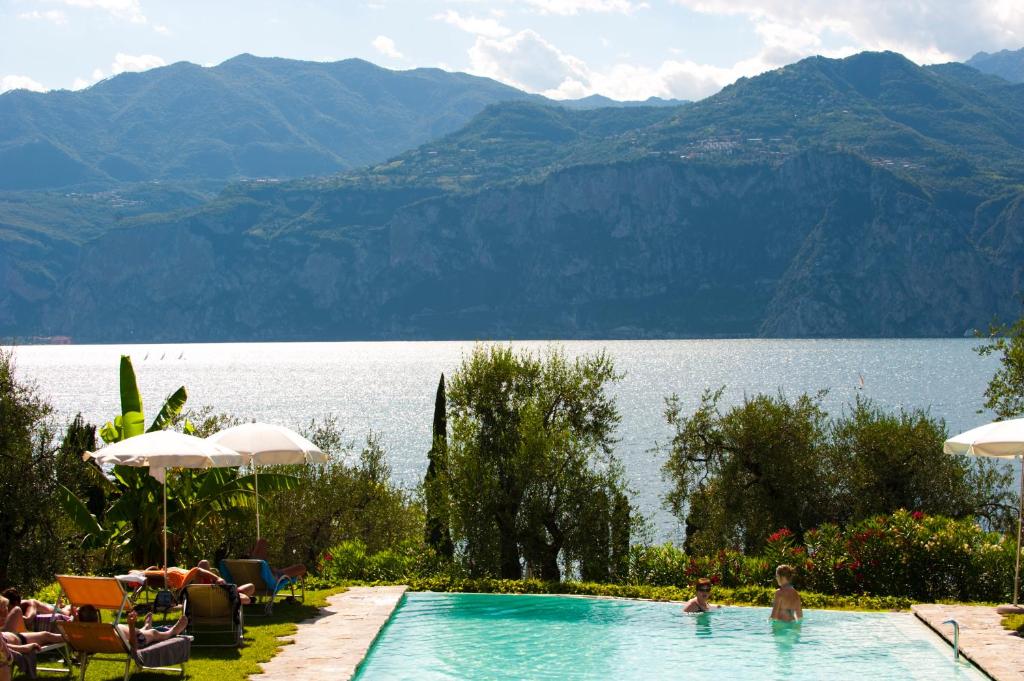 una piscina con vista sul lago e sulle montagne di Hotel Internazionale a Malcesine