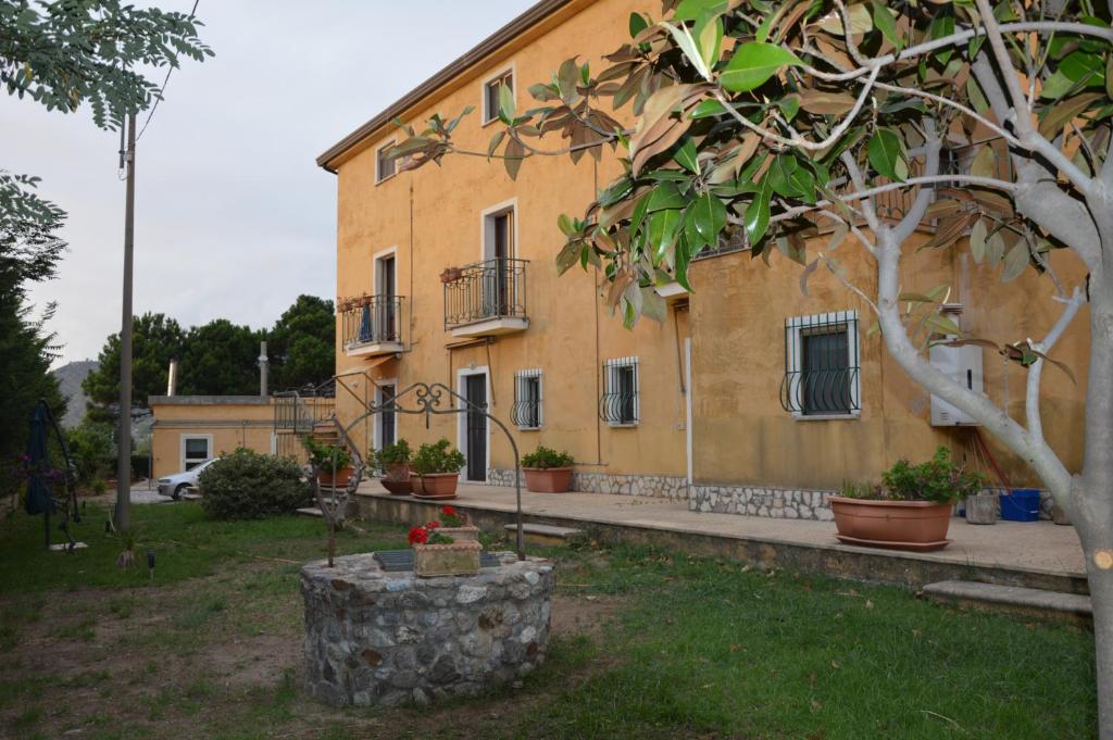 a yellow building with potted plants in front of it at Residence Verde Blu in Fuscaldo