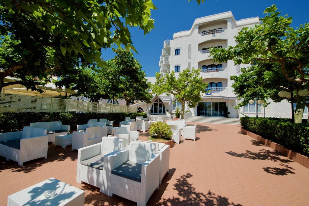 una fila di sedie bianche di fronte a un edificio di Bajamar Beach Hotel a Formia