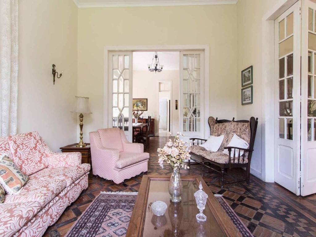 a living room with a couch and chairs and a table at Casa de Petrópolis-Sítio Temporada in Petrópolis