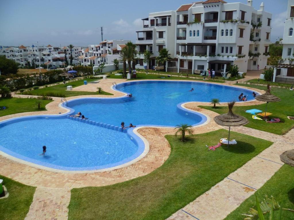 a large swimming pool with people in a resort at Cabobeach Appartement in Cabo Negro